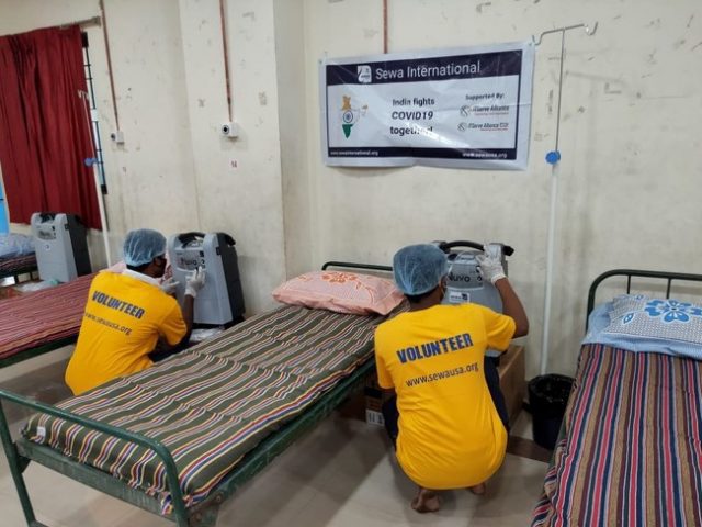 Sewa International, Volunteers are Seen Setting up Oxygen Concentrators in a COVID-19 Care Center in India 